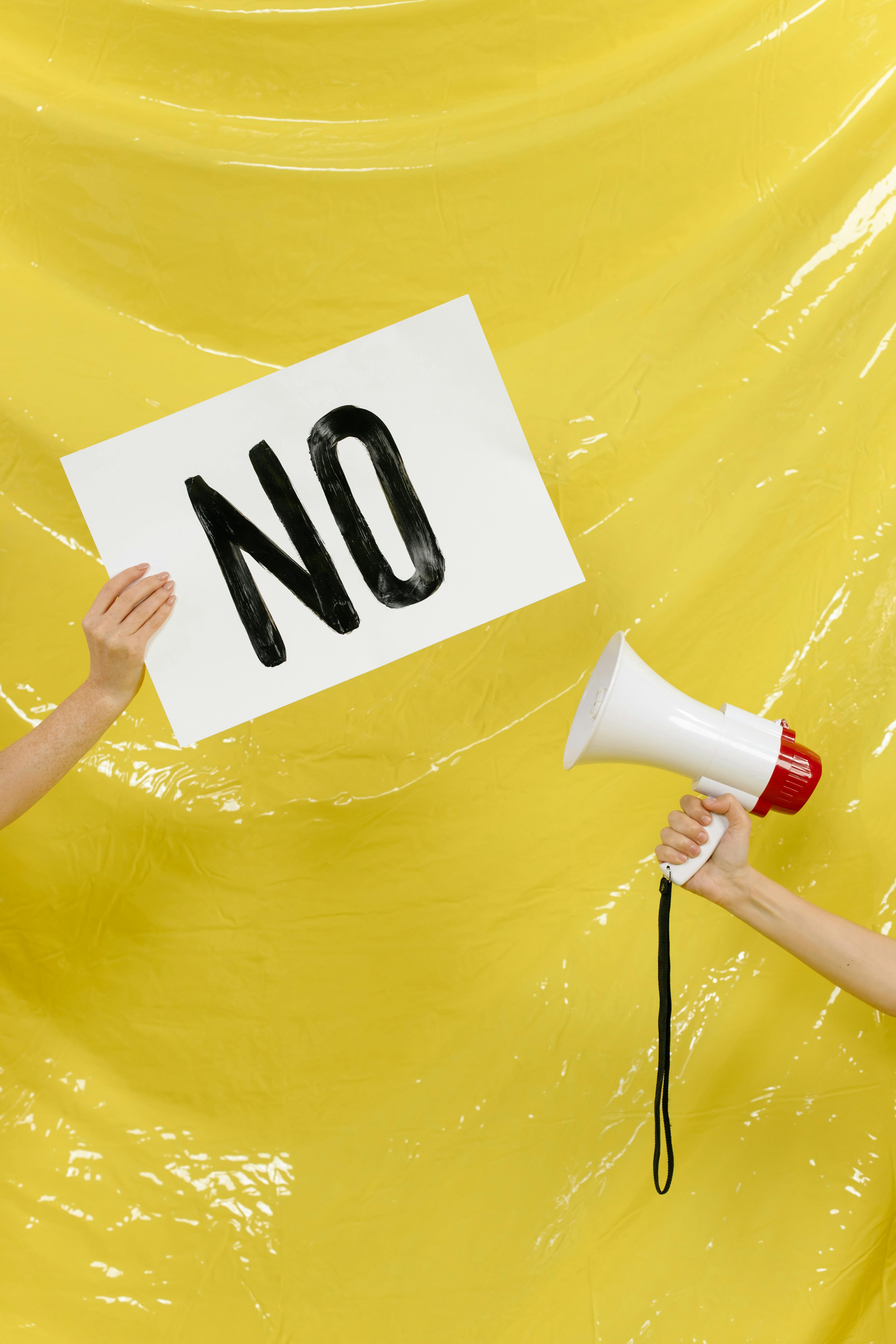 Conceptual protest image with a placard and megaphone against a yellow backdrop.